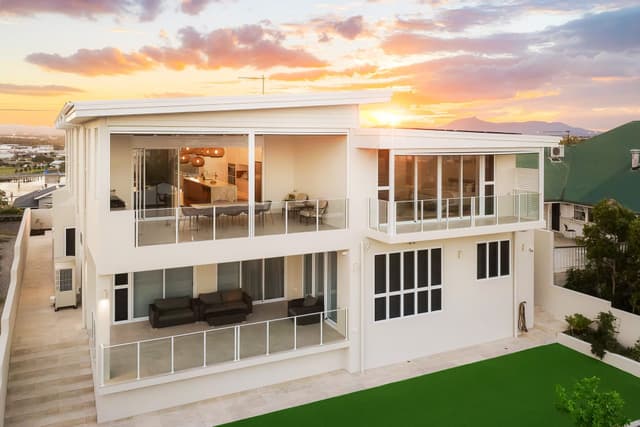 Aerial view of two-storey home with balconies at sunset