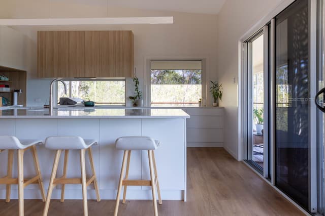 Kitchen island with bar stools and bush views